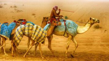 A man riding a camel in the desert photo