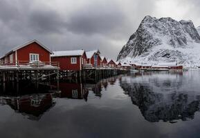 Red houses on the shore of a lake with mountains in the background photo