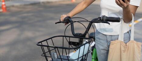 Sustainability and Urban Transportation. A person enjoying a moment of connection while checking their phone next to a bicycle. photo