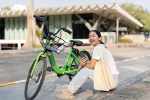 Community Engagement and Eco-Friendly Practices. A woman smiles while sitting beside her bicycle, encouraging sustainability. photo