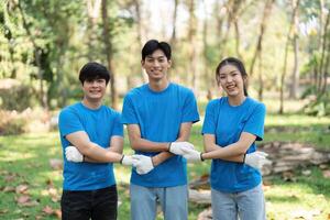 Community and Collaboration. Three smiling volunteers posing together after a successful park cleanup, fostering relationships through environmental action. photo