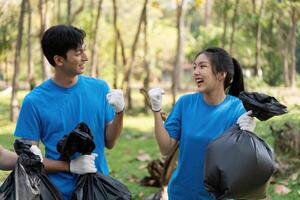 Community Cleanup and Environmental Action. Volunteers expressing excitement while collecting waste in garbage bags. photo