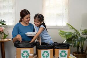 Eco-Parenting and Environmental Stewardship. A mother and child recycling together, promoting green habits in daily life. photo