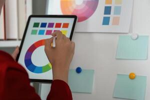 Graphic Design Process and Color Exploration. A designer analyzes color patterns on a digital device. photo