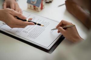 Contract Signing and Paperwork in Real Estate. A couple reviews a contract while consulting with their real estate agent. photo