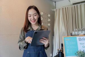 Technology and Customer Interaction. A barista uses a tablet to enhance the customer experience in an eco-friendly cafe. photo