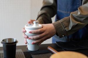 Eco-friendly Practices and Customization. A barista prepares a reusable cup for a customer while ensuring sustainability in service. photo
