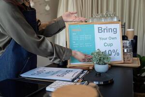 Sustainable Practices and Eco-Friendly Initiatives. A cafe promoting the bring-your-own-cup policy to encourage sustainability. photo