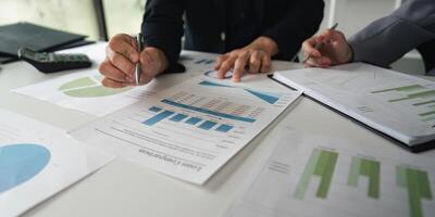 Analysis and Data Review. Close-up of colleagues reviewing financial reports and graphs together. photo