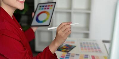 Design and Color Theory. An artist using a digital tablet to explore vibrant color palettes. photo