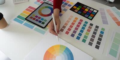 Color Selection and Digital Creation. An artist's hand selects color swatches for creative projects. photo