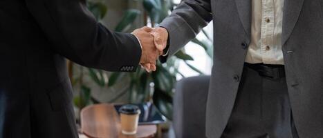 Professional Connection and Agreement. A close-up of two hands shaking, marking a collaboration in a stylish workspace. photo