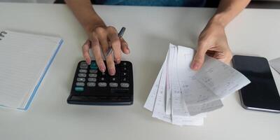 Budgeting and Expense Tracking. A person calculating expenses with receipts and a calculator, focusing on financial responsibility. photo