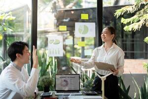 Effective Team Meeting on Sustainable Initiatives. Presenters share insights and discuss eco-friendly strategies with visuals. photo