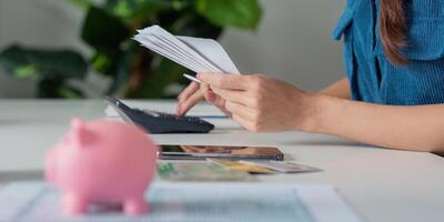 Savings and Budgeting Techniques. A person organizing bills while a piggy bank sits prominently on the table. photo