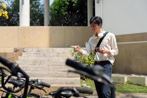 Bicycle Usage and Smartphone Technology. A person navigating a bike parking area, seeking an available bicycle. photo