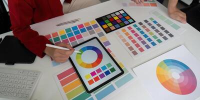 Color Selection and Design Collaboration. A designer selects colors while sharing insights with a colleague. photo
