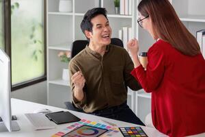 Creativity and Collaboration. A graphic designer and colleague celebrate their brainstorming session in a bright workspace. photo