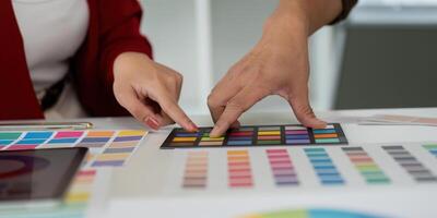 Graphic Design and Team Collaboration. Team members discuss color palettes and creative ideas in a vibrant workspace. photo