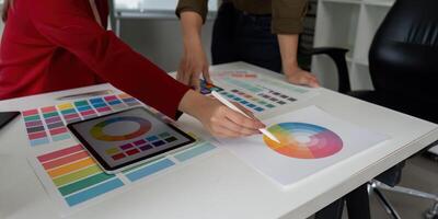 Color Theory and Teamwork. Designers discussing color theory while working on digital and printed palettes. photo