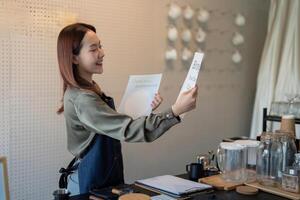 Eco-Friendly Initiatives and Customer Interaction. A barista enthusiastically displaying a message about sustainable practices. photo