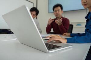 Focused Discussion and Design Review. Team members discussing UX strategies while referencing digital prototypes on a laptop. photo