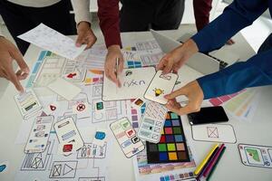 Design Process and Creative Input. Team examining design elements together to enhance digital user experience. photo
