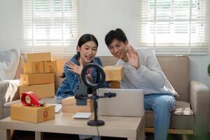 Virtual Engagement and Product Presentation. The duo waves at their audience during a live unboxing session, showcasing their newly arrived products. photo