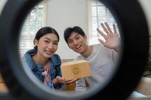 Branding and Product Promotion. A joyful couple showcasing their product box while preparing for an online presentation. photo