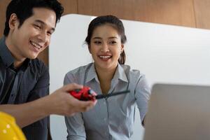 Team Collaboration and Technology. Two engineers smiling while using a communication tool to coordinate their project effectively. photo