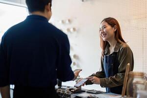 Sustainable Practices and Customer Engagement. A barista sharing eco-friendly options with a customer at the cafe. photo
