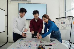 Teamwork and Prototyping. Designers collaboratively developing UX solutions while analyzing wireframes and color choices. photo