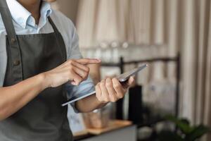 Digital Orders and Efficient Service. A barista navigates a tablet while assisting customers in a stylish coffee shop. photo
