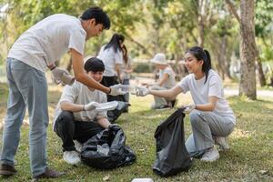 Volunteers exchanging materials during a park cleanup, emphasizing teamwork and environmental stewardship. photo