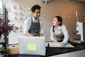 Collaboration and Planning. Two baristas strategizing and discussing business ideas in a contemporary cafe atmosphere. photo