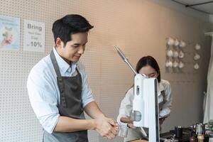 Coffee Preparation and Teamwork. A barista working behind the counter while another assists in making coffee drinks. photo