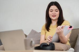 Work from Home and Virtual Collaboration. A young professional engages in an online meeting while reviewing important documents. photo