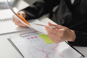 Business Growth and Data Analysis. A business professional analyzing data trends while referring to tax documents. photo
