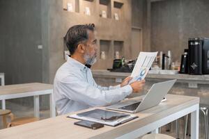 Analysis and Business Insights. A consultant reviewing business charts with a senior client in a workspace. photo