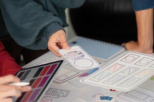 User Experience Design and Presentation. Designers showcasing mobile user interface layouts while discussing project ideas. photo