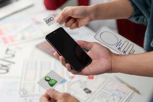Design Elements and Branding in UX. Team members conceptualizing designs with prototypes in hand, ready to innovate. photo