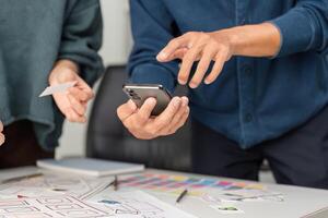 Mobile App Design and User Interaction. Professionals exploring mobile interface designs while engaging in collaborative discussions. photo