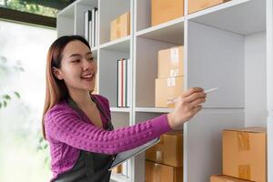 Online Selling and Inventory Management. A cheerful woman labeling packages in her organized workspace, demonstrating efficient online selling practices. photo