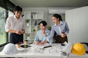 Collaboration and Planning. A group discussing architectural plans and project details around a table. photo