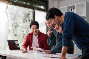Creative Collaboration in UIUX. Diverse team members engaging in design discussions over project materials. photo