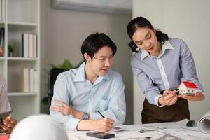 Design Collaboration and Problem Solving. Team members reviewing architectural plans and models together. photo