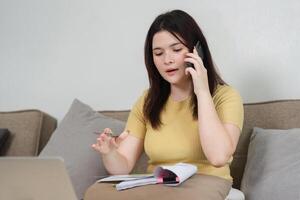 Effective Communication and Support. A woman makes a phone call to discuss important work matters while working remotely. photo