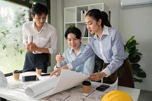 Design and Innovation. Professionals collaborating over building plans and drafts. photo