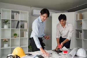 Building Plans and Collaboration. Two professionals analyzing architectural plans and discussing measurements. photo