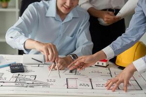 Collaboration and Architectural Planning. Two professionals collaborating on building design plans with materials and tools. photo